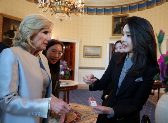 윤석열 대통령의 부인 김건희 여사가 지난달 25일(현지시간) 미 워싱턴DC 백악관 관저에서 열린 친교행사에서 조 바이든 미국 대통령의 부인 질 바이든 여사와 준비한 선물을 교환하고 있다. 공동취재=연합뉴스